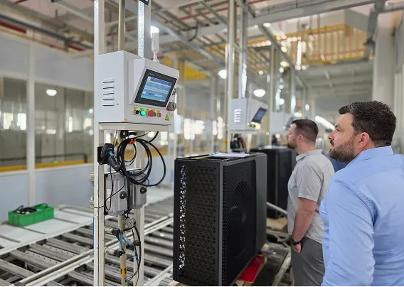 Geschäftsführer der Waermequelle GmbH Felix Cvecko, der auf einen Monitor in einer Produktionshalle für Wärmepumpen schaut.