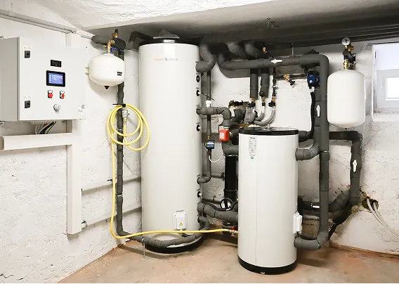 Die Innentechnik nach dem Einbau einer Wärmepumpe der Firma Waermequelle im Heizungsraum eines Hauses.