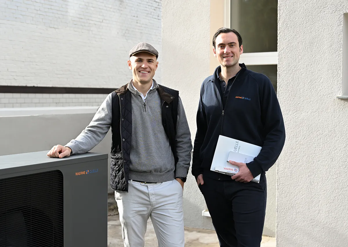 Youri Kissner, Geschäftsführer der Waermequelle GmbH, mit einem Kunden vor einer Wärmepumpe stehend.