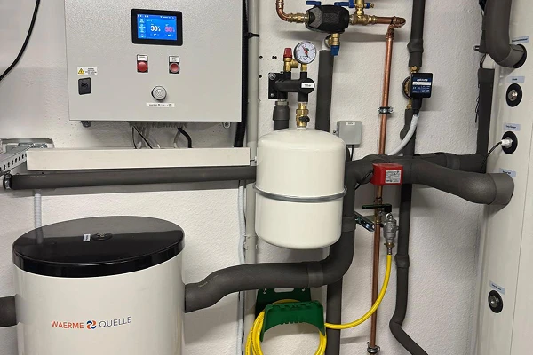 Die Innentechnik nach dem Einbau einer Wärmepumpe der Firma Waermequelle im Heizungsraum eines Hauses.