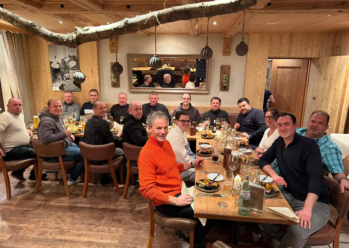 Das Team der Waermequelle GmbH an einem großen Holztisch in einem Restaurant.