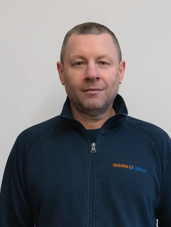 Porträt eines Mitarbeiters der Waermequelle GmbH mit dunkelblauer Jacke mit Waermequelle Logo.