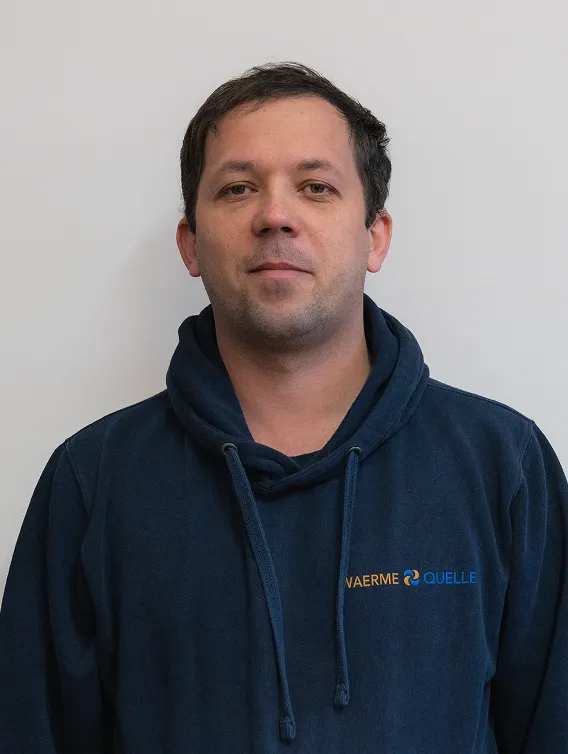 Porträt eines Mitarbeiters der Waermequelle GmbH mit dunkelblauer Jacke mit Waermequelle Logo.