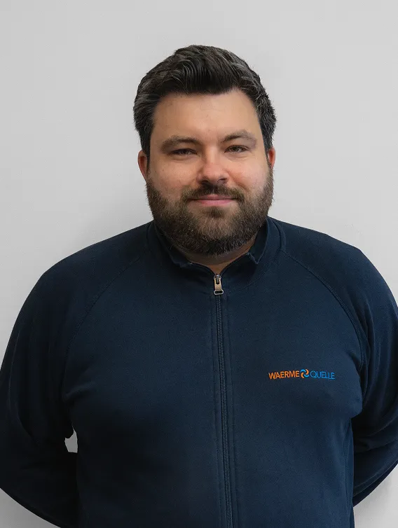 Porträt eines Mitarbeiters der Waermequelle GmbH mit dunkelblauer Jacke mit Waermequelle Logo.