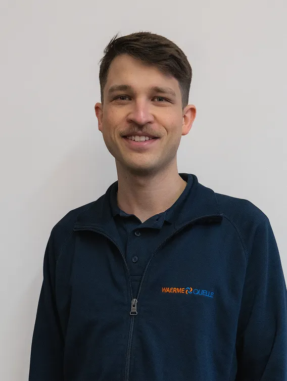 Porträt eines Mitarbeiters der Waermequelle GmbH mit dunkelblauer Jacke mit Waermequelle Logo.