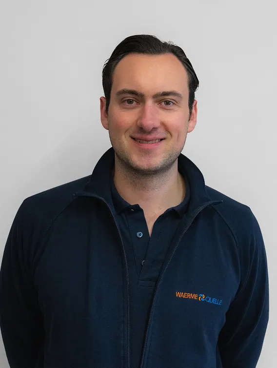 Porträt eines Mitarbeiters der Waermequelle GmbH mit dunkelblauer Jacke mit Waermequelle Logo.
