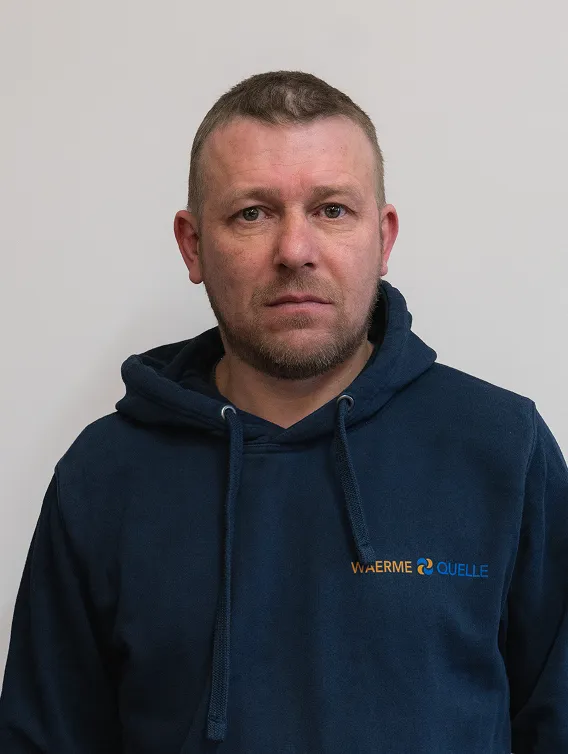 Porträt eines Mitarbeiters der Waermequelle GmbH mit dunkelblauer Jacke mit Waermequelle Logo.