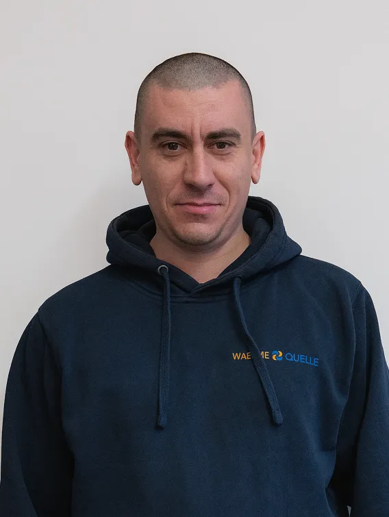 Porträt eines Mitarbeiters der Waermequelle GmbH mit dunkelblauer Jacke mit Waermequelle Logo.